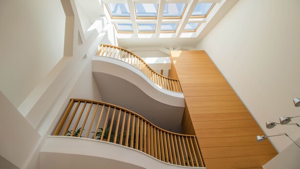 A modern interior with a curved staircase, wooden railings, and skylights. - Horeum Boutique Hotel (Sura Mare)