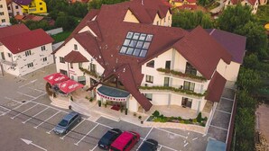 A multi-story building with a sloped roof, a central courtyard, and a restaurant named "Ursus" with outdoor seating. - Horeum Boutique Hotel (Sura Mare)