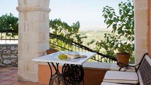 A patio with a table and chairs, a bench, and a view of the countryside. - Kastellos Village - Agathes Houses (Apokoronas)