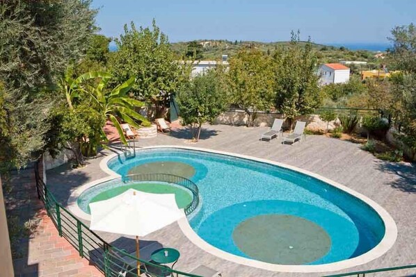 Piscine extérieure en saison, parasols, chaises longues