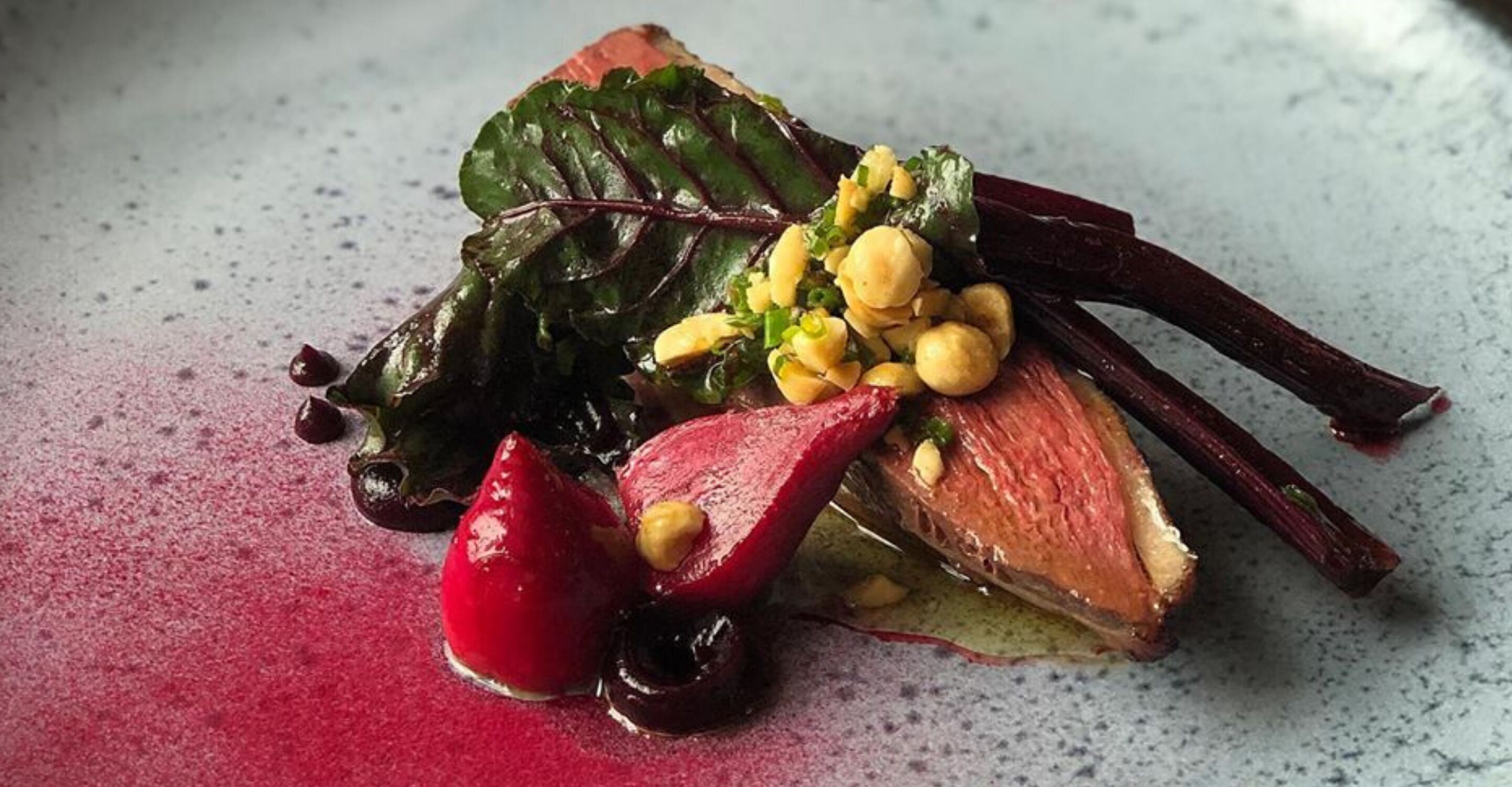 Un plat composé de légumes verts, de betteraves et de pois chiches, servi dans une assiette.