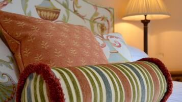 A bed with a striped pillow and a patterned pillow.