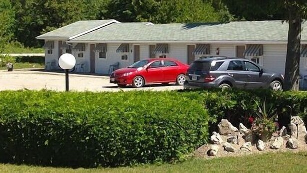 A row of single-story mobile homes with a parking area in front. - Cedar Vista Motel (Northern Bruce Peninsula)
