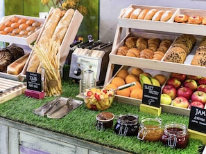 A bakery display with various breads, pastries, and fruits. - Ibis Styles Lviv Center (Lviv)