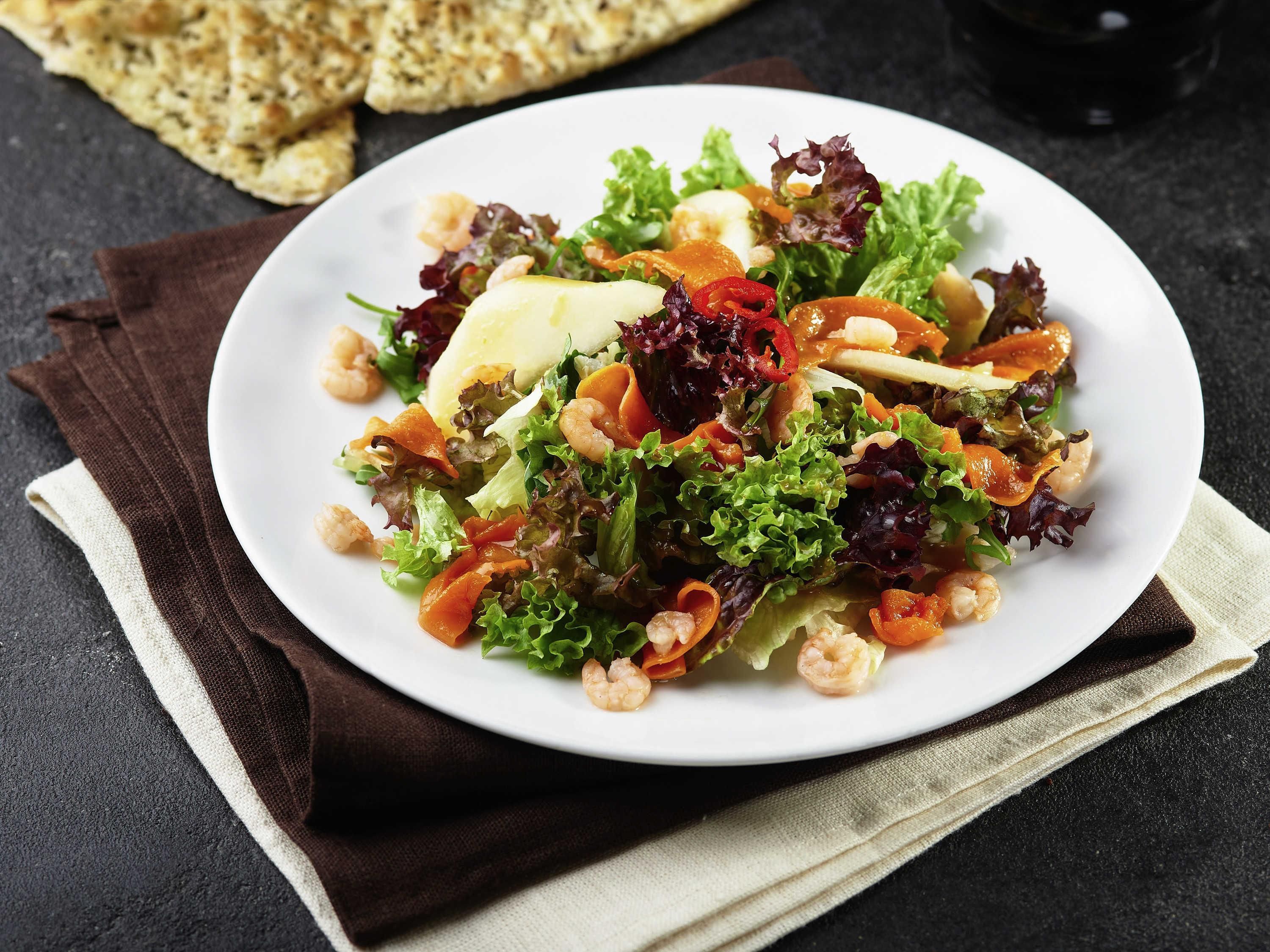 Un piatto di insalata con diverse verdure e ceci.