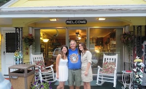 A welcoming entrance with a 'WELCOME' sign, white chairs, and a small table outside a shop. - Lake Winnipesaukee Motel (Laconia)