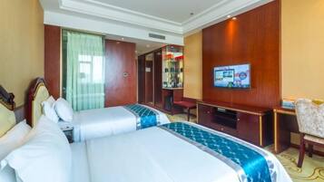 Habitación de hotel con dos camas, televisión, escritorio y una silla.