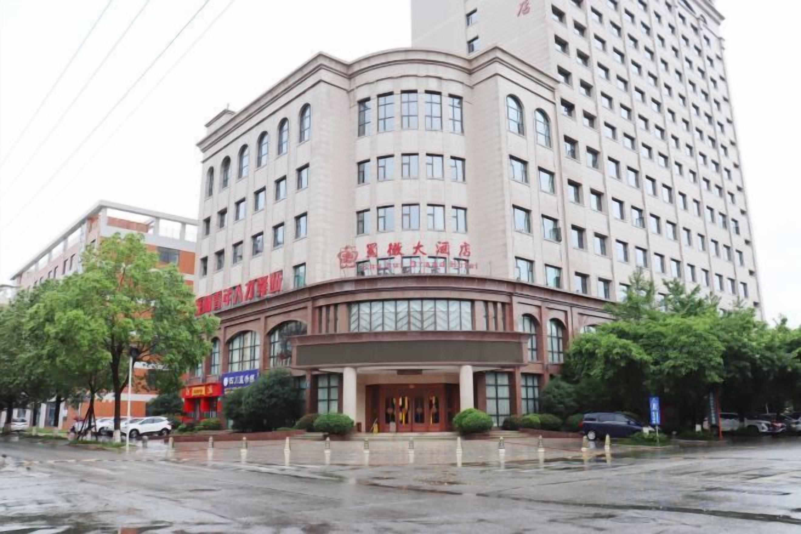 A multi-story hotel with a curved facade, large windows, and a prominent entrance.