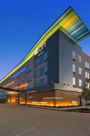 A hotel with a modern design, featuring a prominent 'AllOff' sign, a flat roof, and a series of windows. - Aloft by Marriott College Station (College Station)
