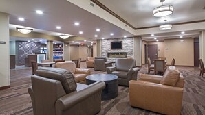 A spacious lobby with leather sofas, a coffee table, and a stone fireplace. - Best Western Plus Lincoln Inn & Suites (Lincoln)