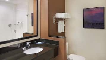 Une salle de bain moderne avec un grand miroir, un lavabo, des toilettes et un porte-serviettes.