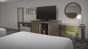 A hotel room with a bed, a desk with a television, a chair, a mirror, and framed pictures on the wall. - Hampton Inn & Suites Georgetown/Austin North (Georgetown)