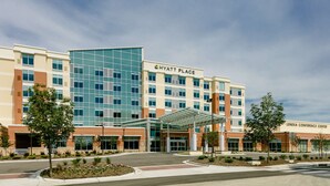 A modern hotel with a glass facade, a covered entrance, and a sign for the Lenexa Conference Center. - Hyatt Place Kansas City/Lenexa City Center (Lenexa)