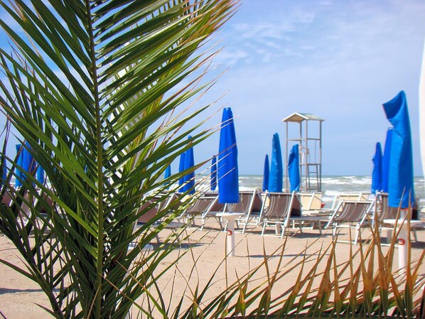 Plage privée, sable blanc, chaises longues, parasols