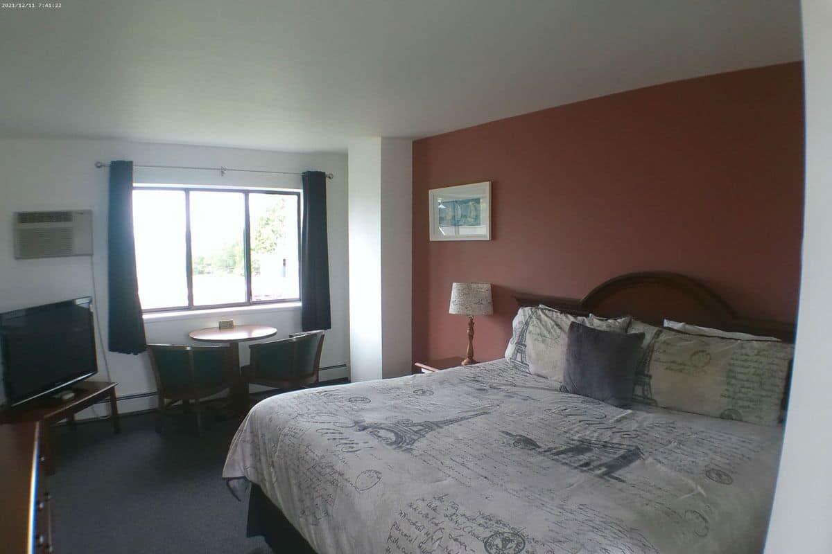 Une chambre d’hôtel avec un lit, une télévision, un bureau et une fenêtre.