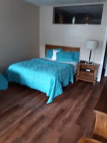 Un dormitorio con una cama, una mesita de noche y una lámpara.
