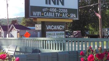 Schild des Northern Peaks Motor Inn mit Annehmlichkeiten wie WLAN, Kabelfernsehen, Klimaanlage und Spa.