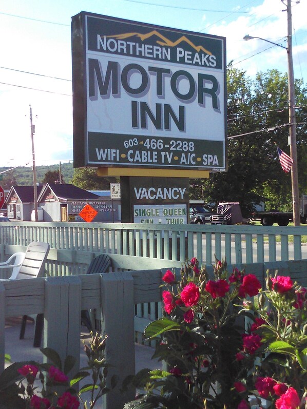 A motel sign with amenities like WiFi, cable TV, A/C, and a spa. - Northern Peaks Motor Inn (Gorham)