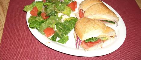 En tallerken med en sandwich og en salat på et bord.