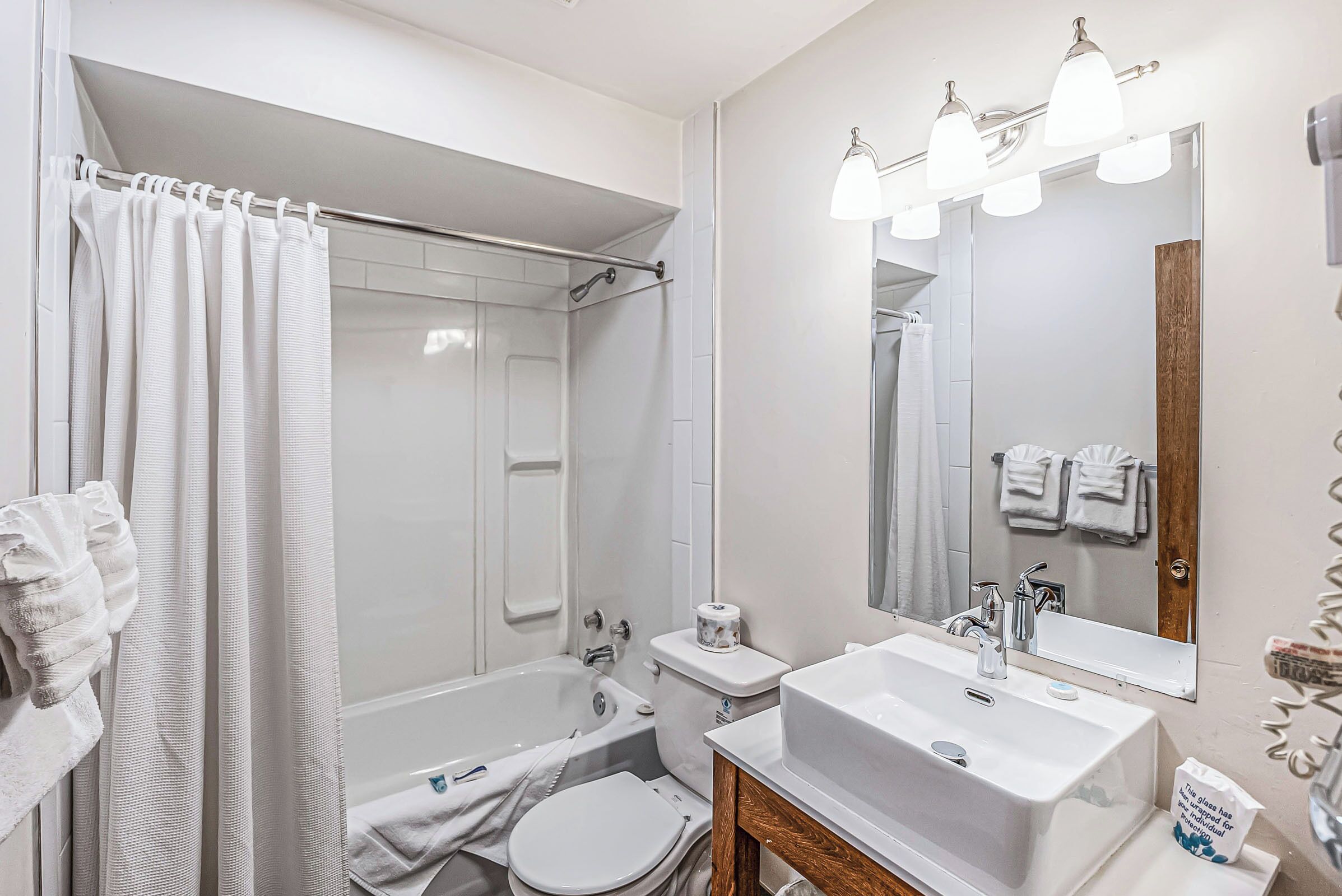 A modern bathroom with a bathtub, toilet, and sink.