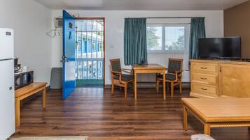 A compact living space with a dining area, a television, and a kitchenette.