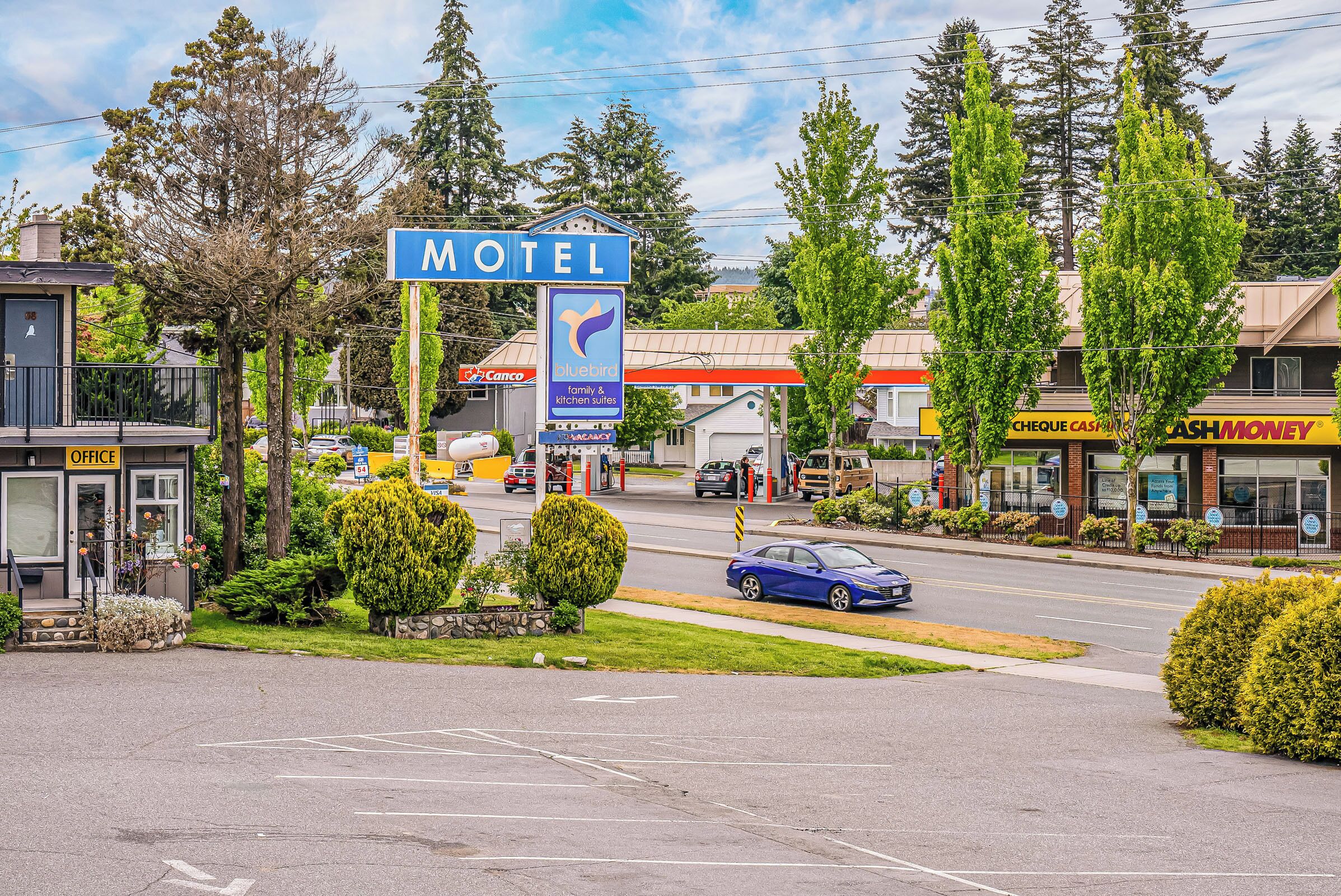 A motel with a prominent sign, a Chevron gas station, and a Bluebird restaurant nearby.