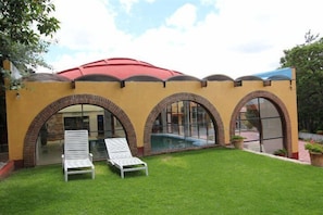 A building with a yellow facade, arched windows, and a swimming pool. - Hotel Villa de la Plata (Guanajuato)