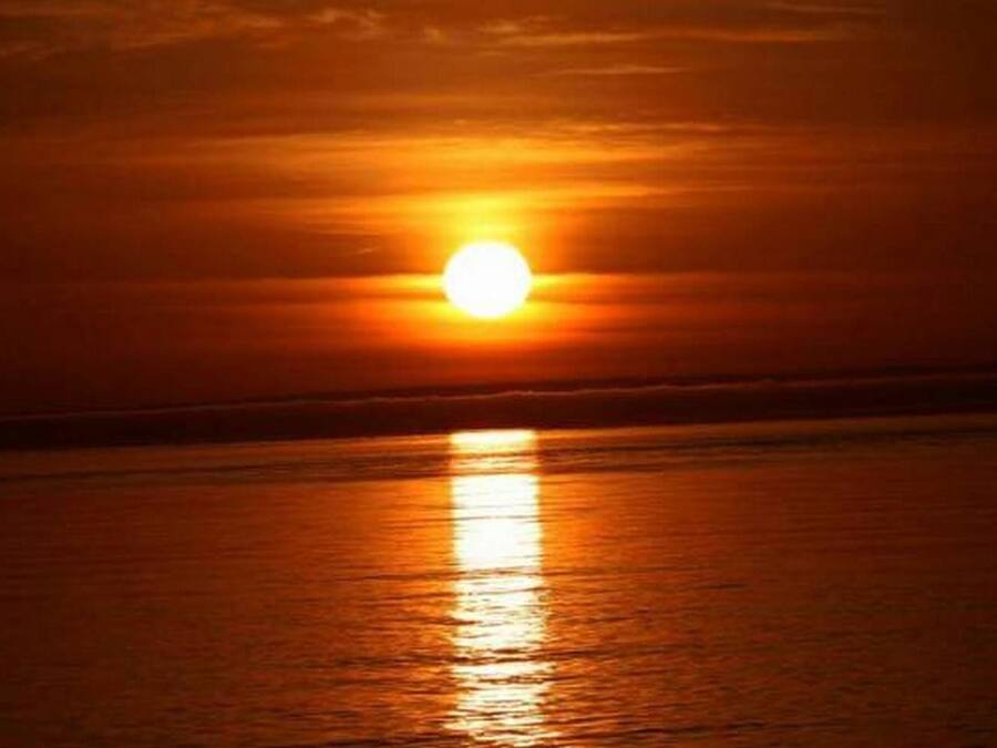 Un coucher de soleil sur une étendue d’eau calme.