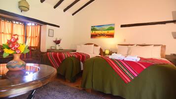 A hotel room with two beds, a small table with a vase of flowers, and a painting on the wall.