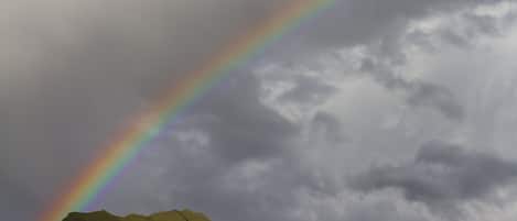 A mountain range with a rainbow arching across the sky.