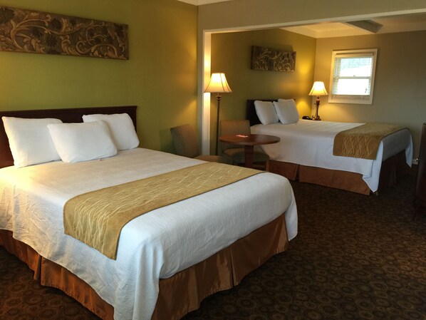 Two single beds with matching headboards and footboards, a small workspace, and a cozy seating area.