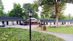 A motel with a row of rooms, a parking area, and a well-maintained lawn. - Kentucky Lake Inn (Gilbertsville)