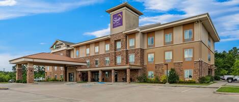 A Sleep Inn hotel with a brick facade, multiple windows, and a covered entrance.