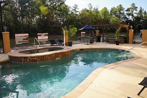 A swimming pool with a hot tub, surrounded by lounge chairs and a covered patio area. - MainStay Suites Lufkin (Lufkin)