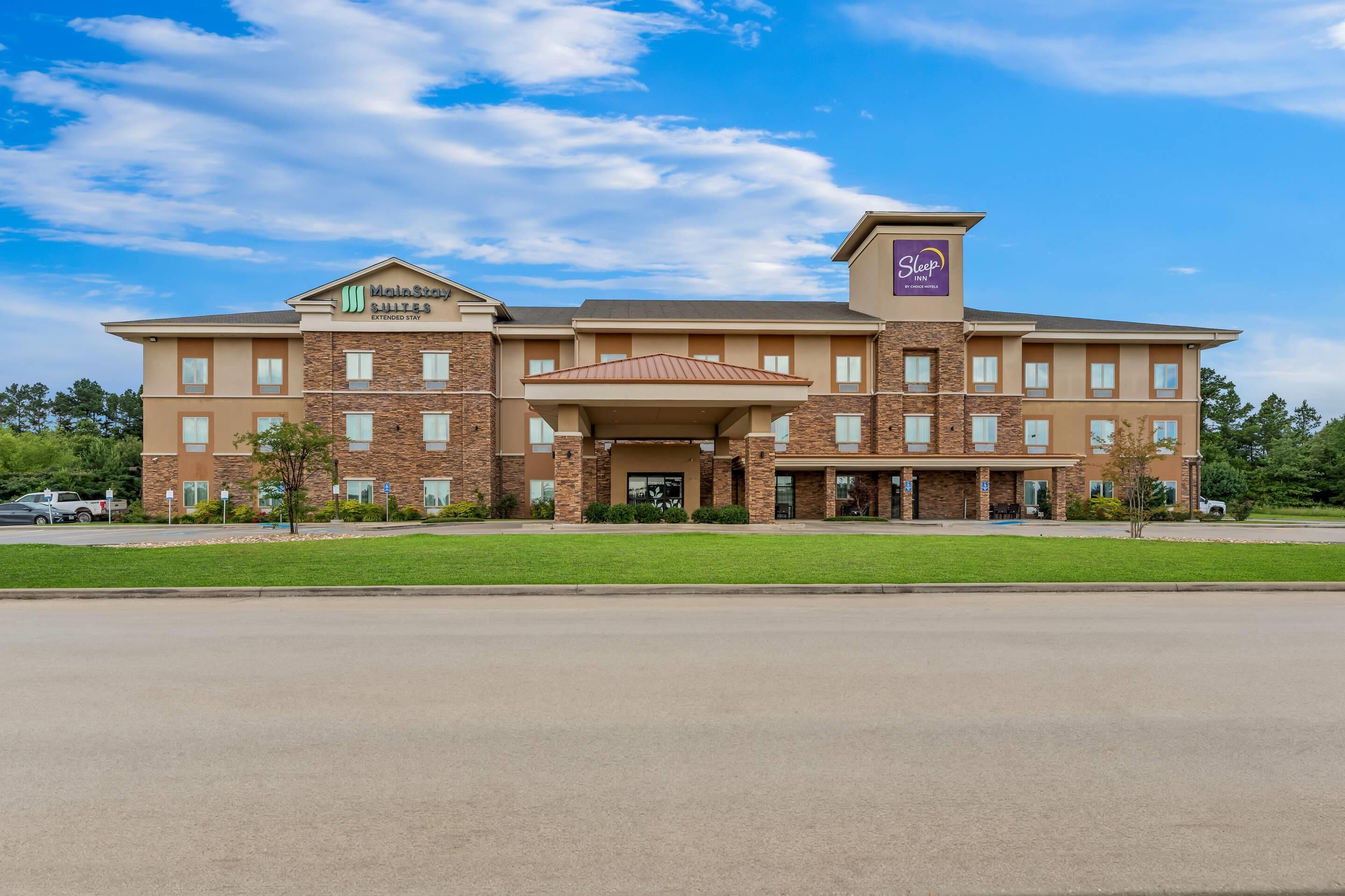 A hotel with a brick facade, a covered entrance, and a sign for 'MainStay Extended Stay'.