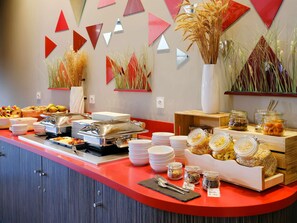 Una mesa de buffet con diversos alimentos y salsas.