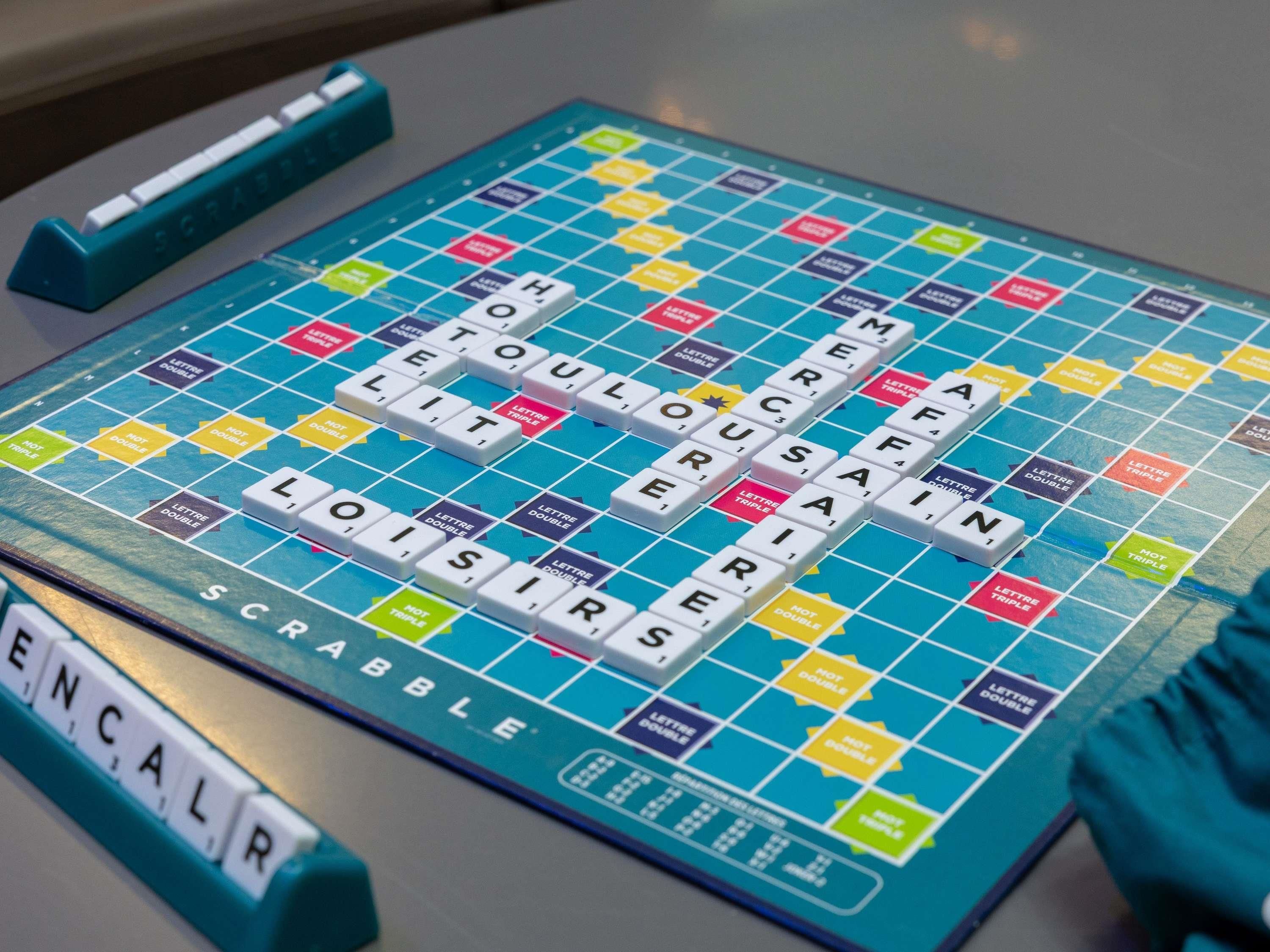 A Scrabble game board with tiles and a Scrabble rack.