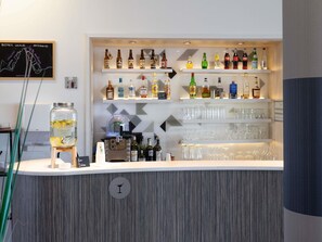 A bar area with shelves of liquor bottles, a Heineken branded machine, and a jar of lemons. - Hôtel Mercure Toulouse Sud (Toulouse)