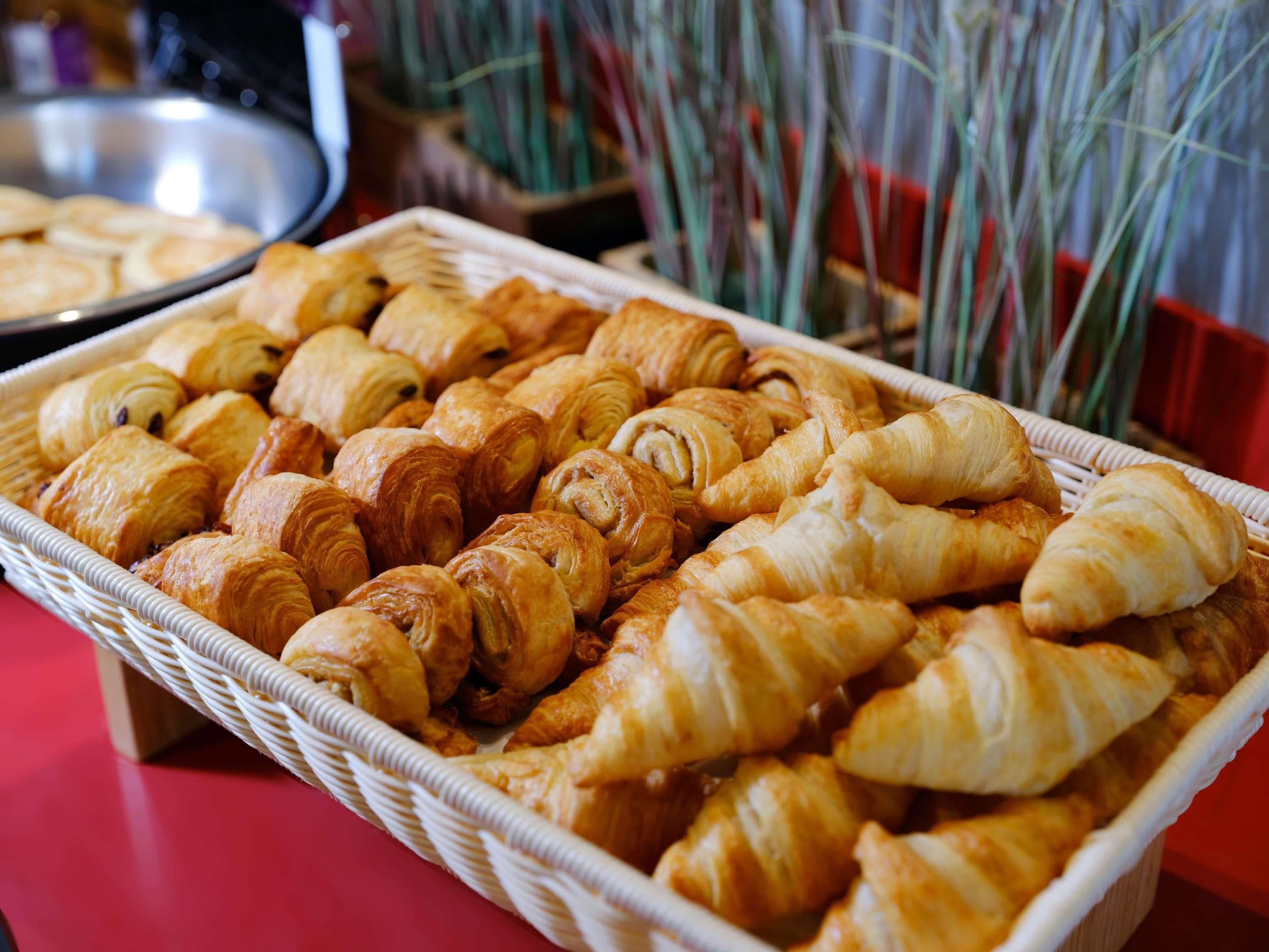 Una cesta con una variedad de pasteles, incluyendo croissants y otras delicias horneadas.