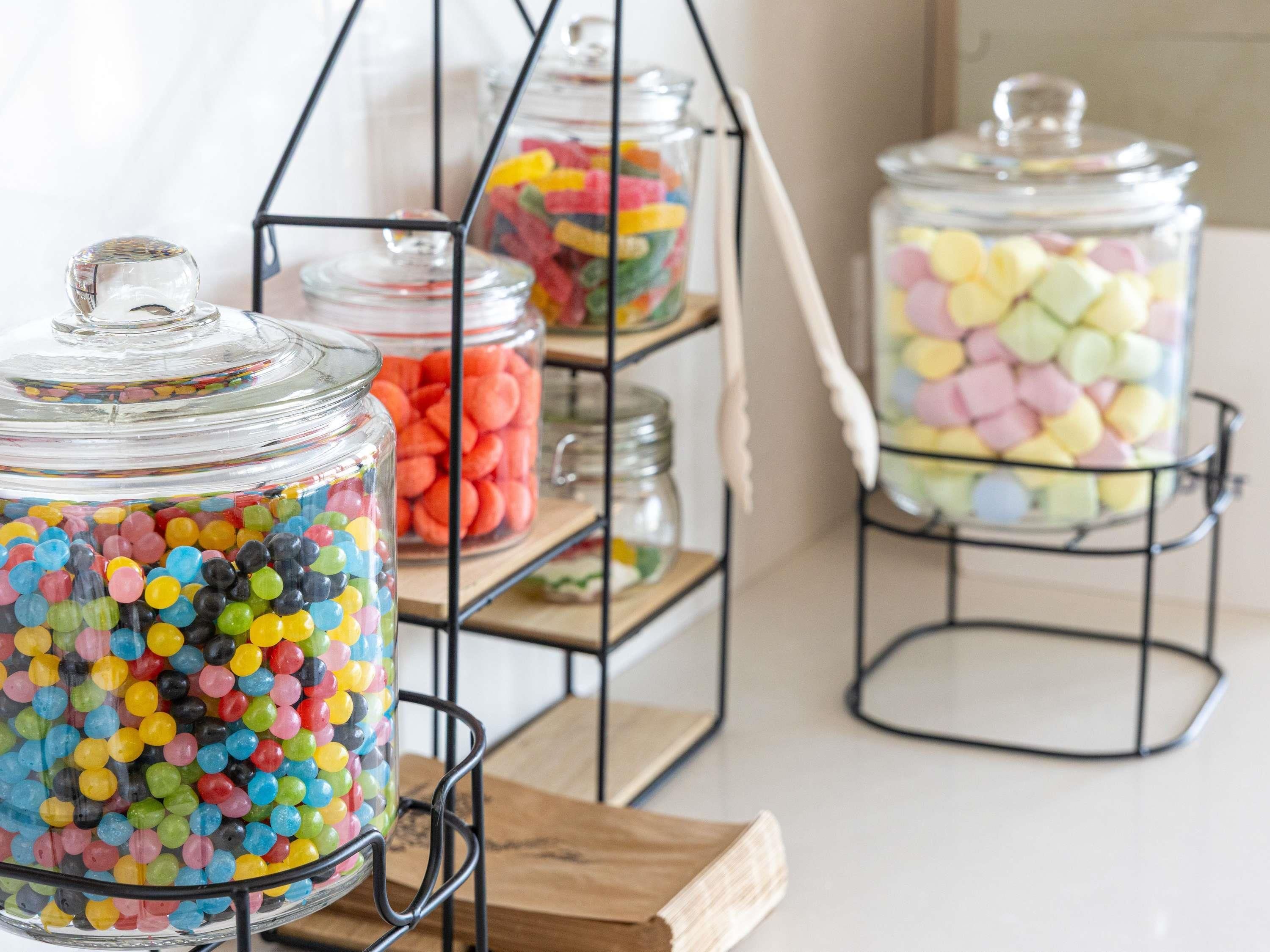 A display of colorful candy jars on a metal rack.