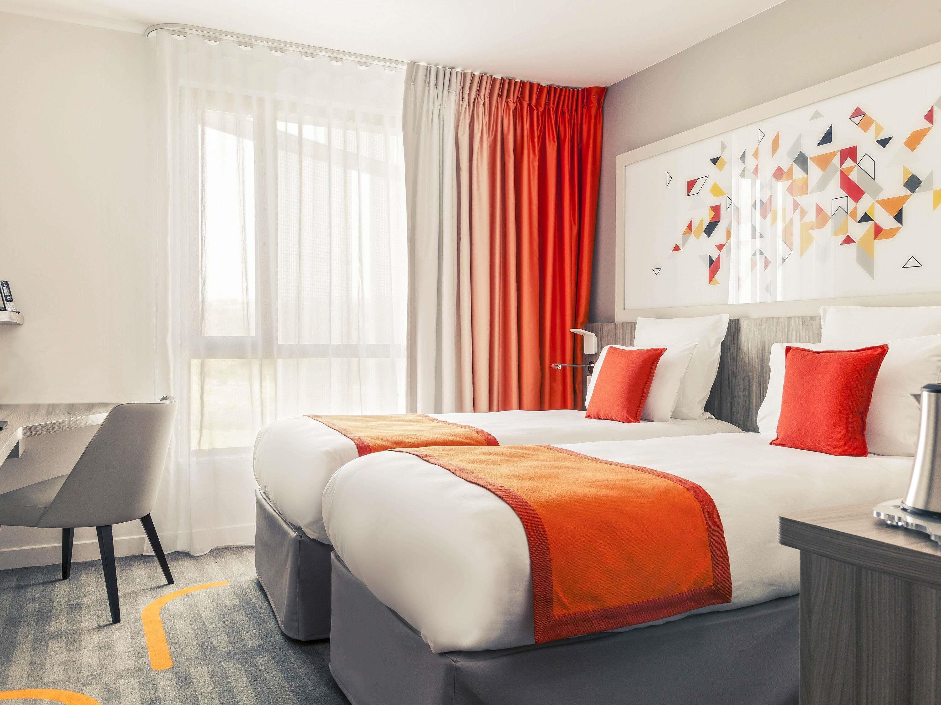 A hotel room with a bed, a desk, and a chair.