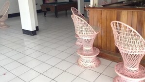 A room with a pool table, pink wireframe chairs, and a wooden bar area. - Marine View Hotel (Ocho Rios)