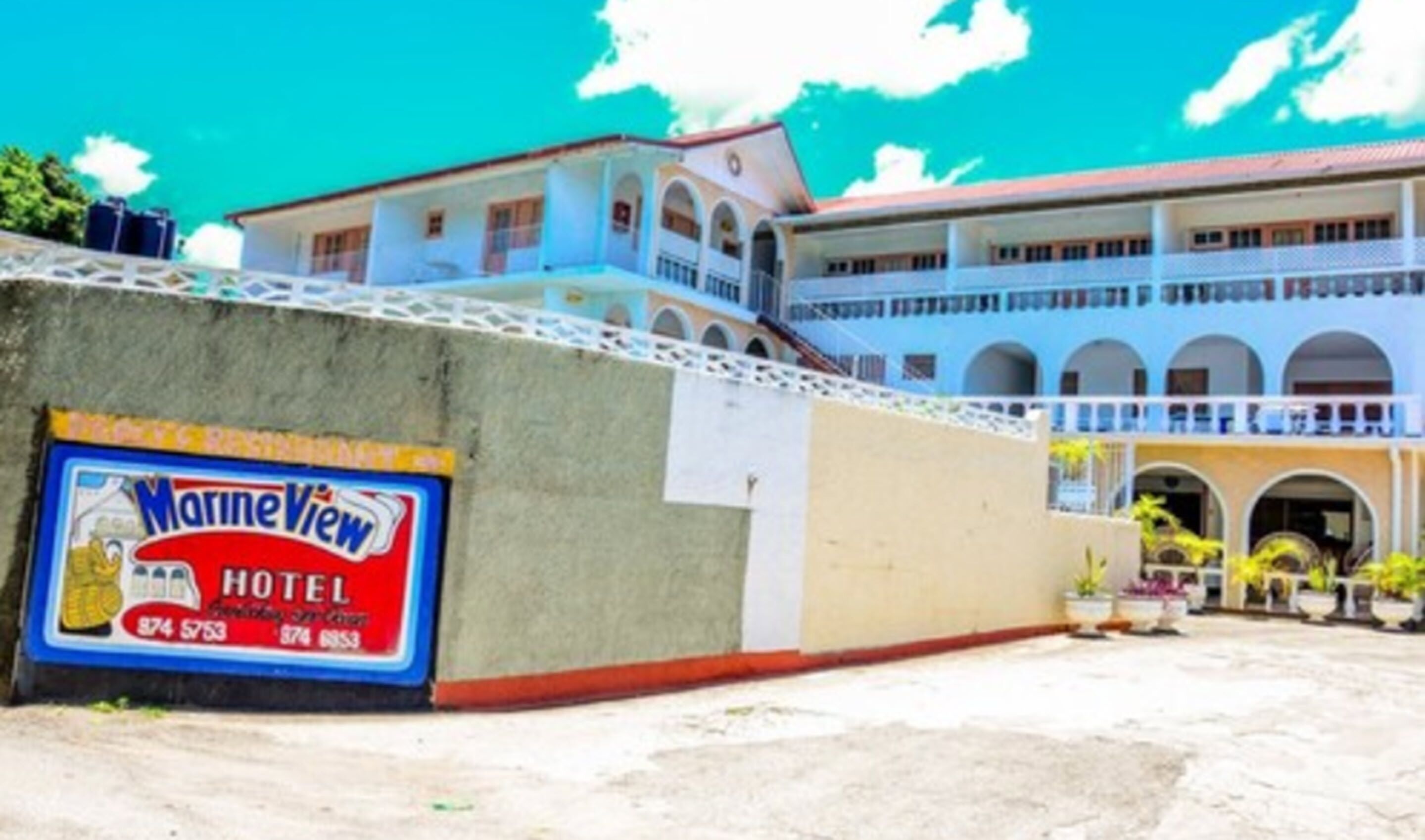 Un hôtel avec une enseigne indiquant « Marine View Hotel », et affichant un numéro de téléphone.