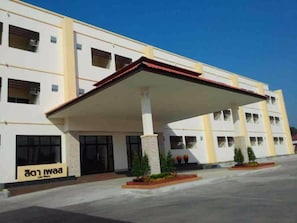 A building with a covered entrance, multiple windows, and a sign that reads "Iwaa".