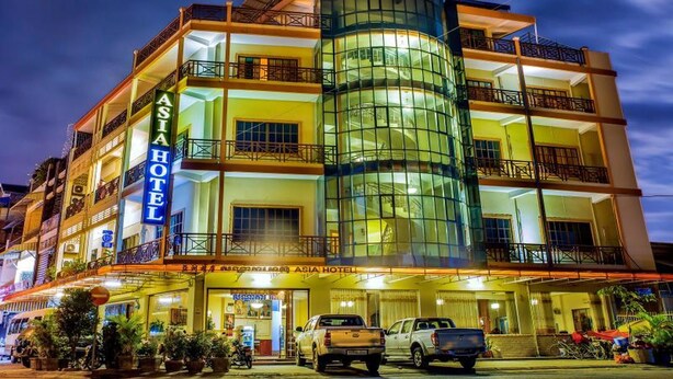 Un hôtel à plusieurs étages doté d’une façade en verre remarquable, de balcons et d’une enseigne indiquant « ASIA HOTEL ».