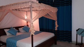 Una cama con dosel, almohadas y una mesita de noche.