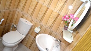 Un baño con inodoro, bidé y lavamanos.