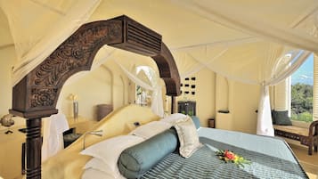 Una cama con dosel, una mesita de noche y vistas al exterior.