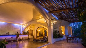 Un espacio interior con una fuente, zona de estar y bar.