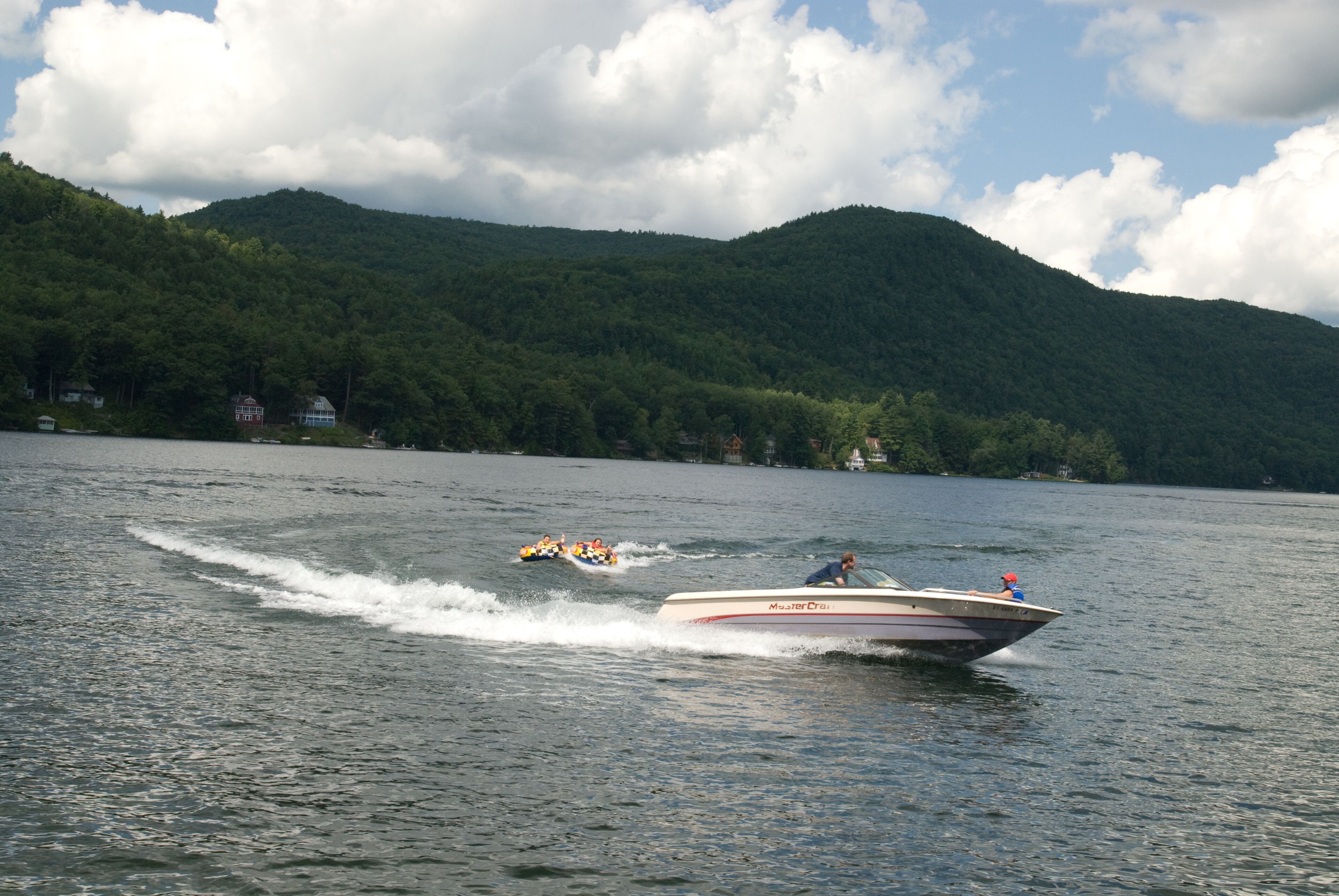 A boat on a lake with a mountainous backdrop.